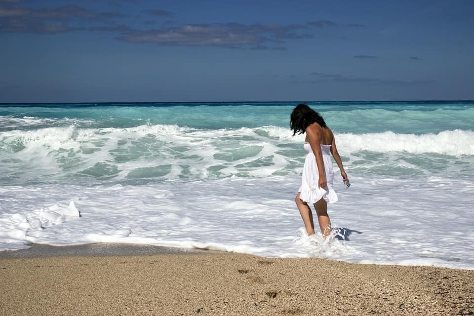 Girl in white dress walking on beach