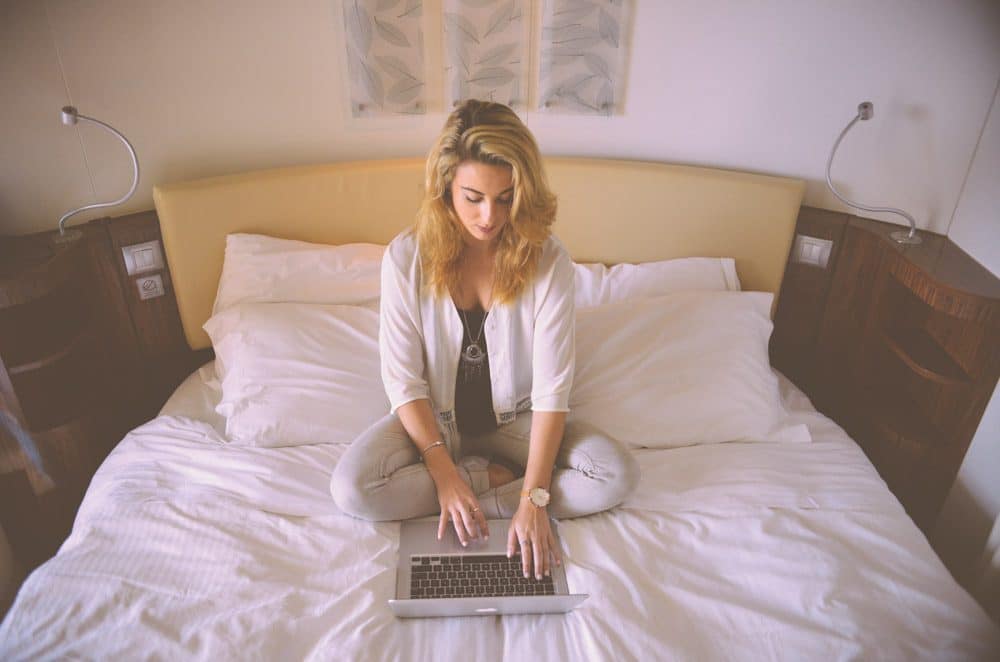 Law school student working on a bed.