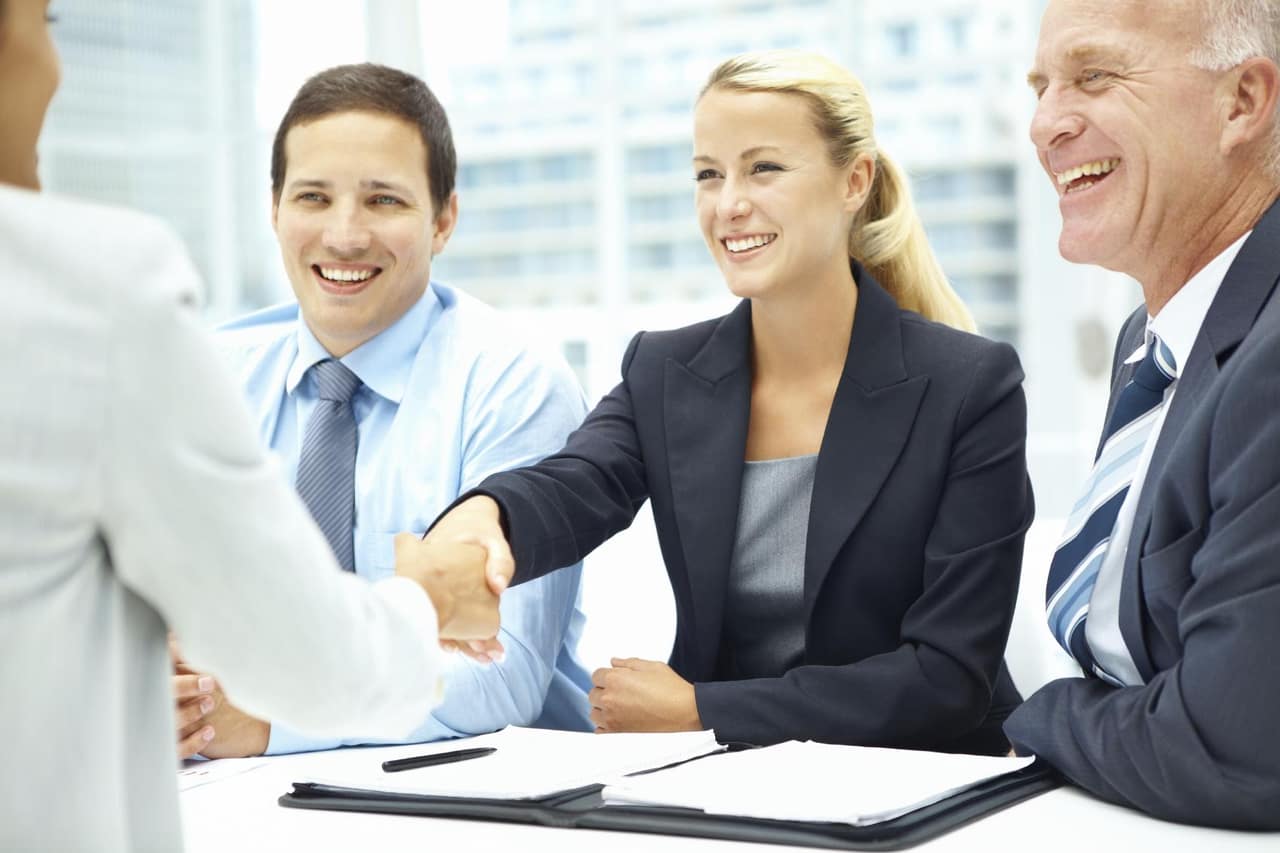 A young businesswoman shaking a new colleague's hand as she accepts the job