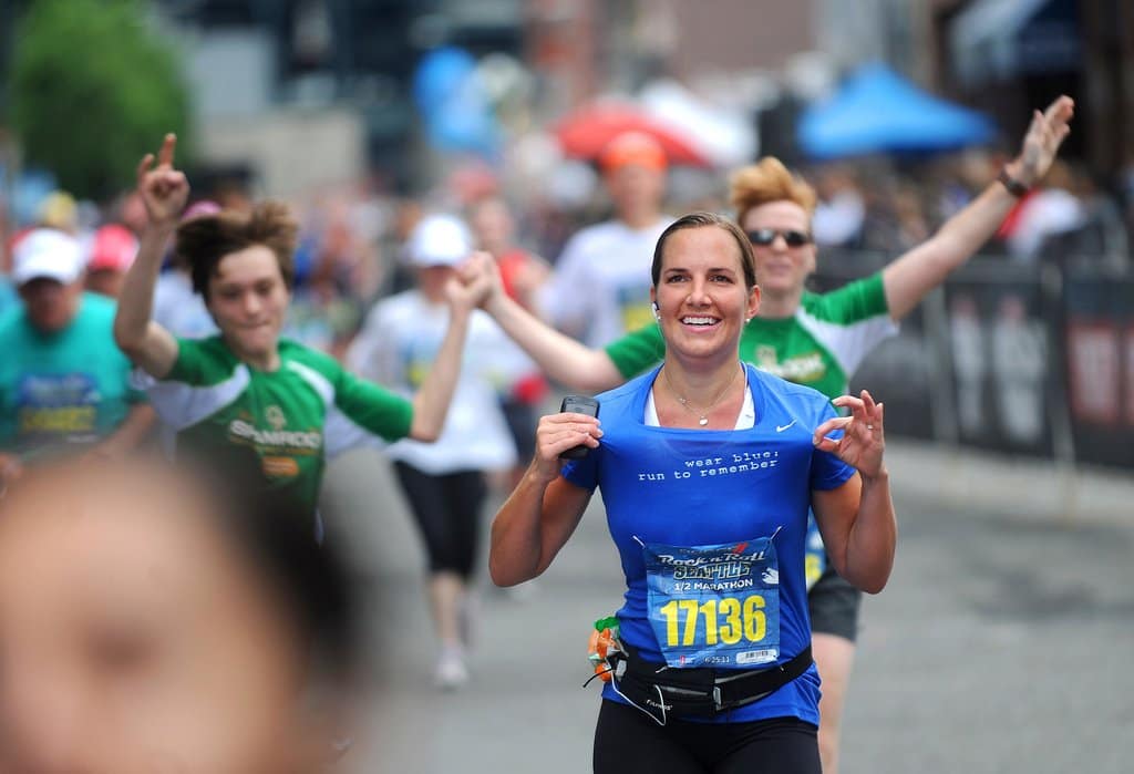 Photo by Ingrid Barrentine

Deb Moffat shows off her "wear blue: run to remember" shirt as she crosses the half marathon finish line at the Rock ÔNÕ Roll Seattle Marathon on Saturday.