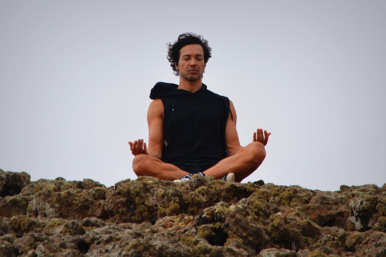 man on mountain meditating