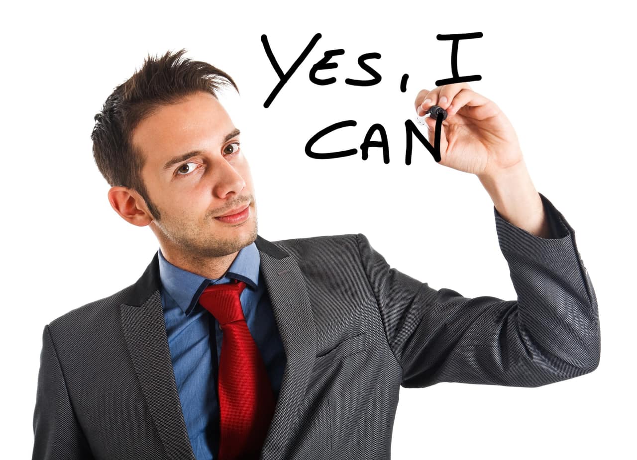 Friendly businessman writing Yes, I can on the screen