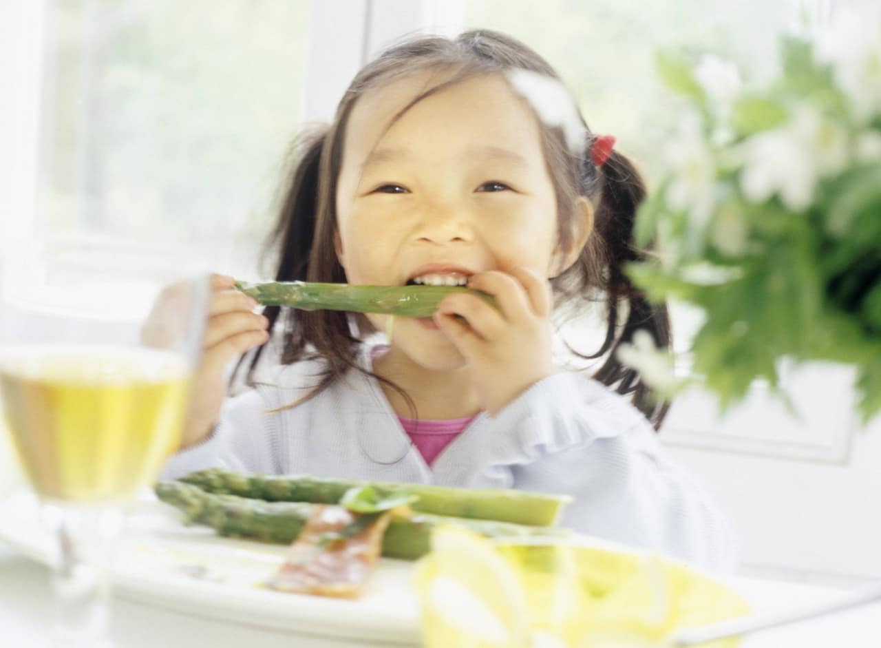 Close-up of a girl eating an asparagus