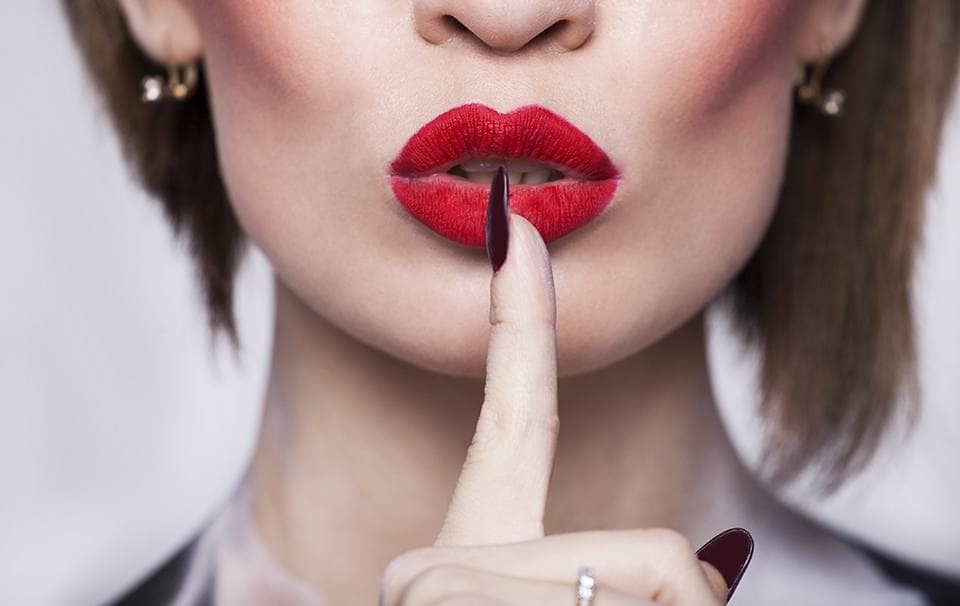 Woman red lips with finger shh