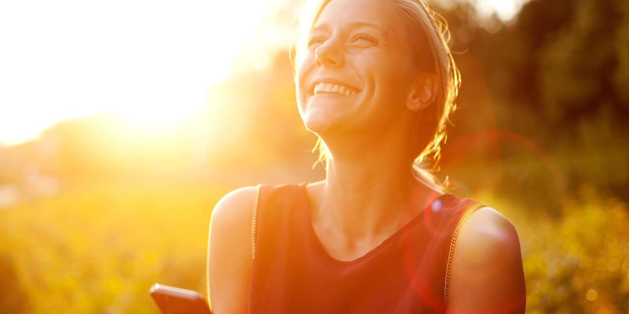 Young woman using smart phone at sunset