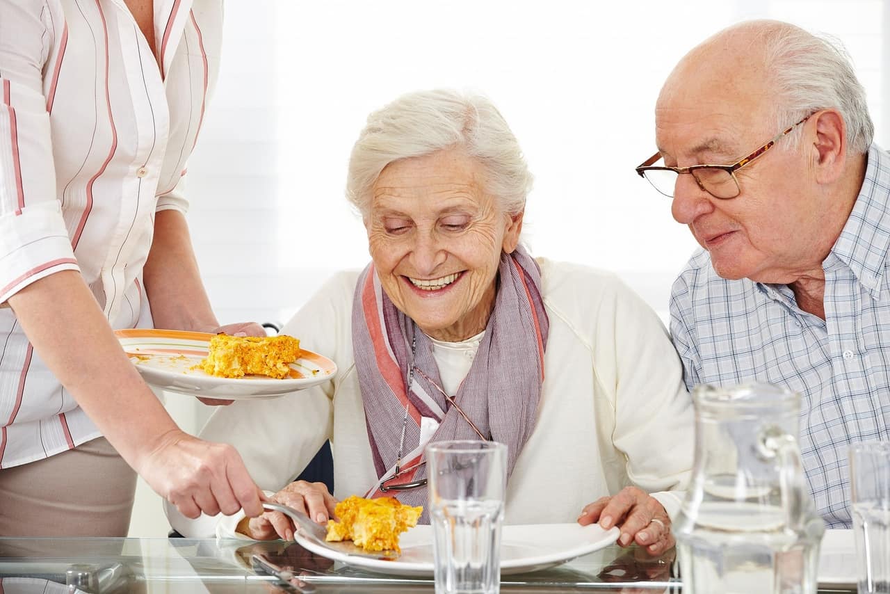 Senior citizens couple eating lunch at nursing home