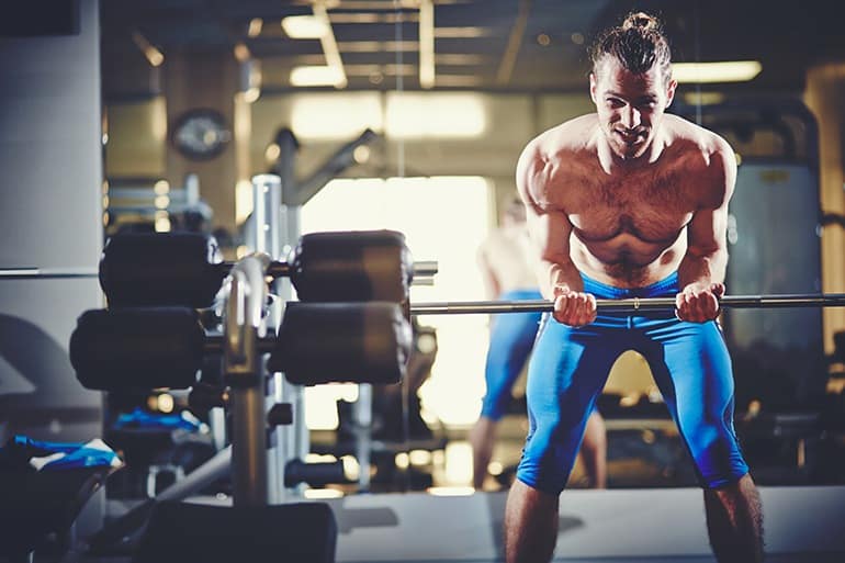 Portrait of sporty topless man with weight looking at camera