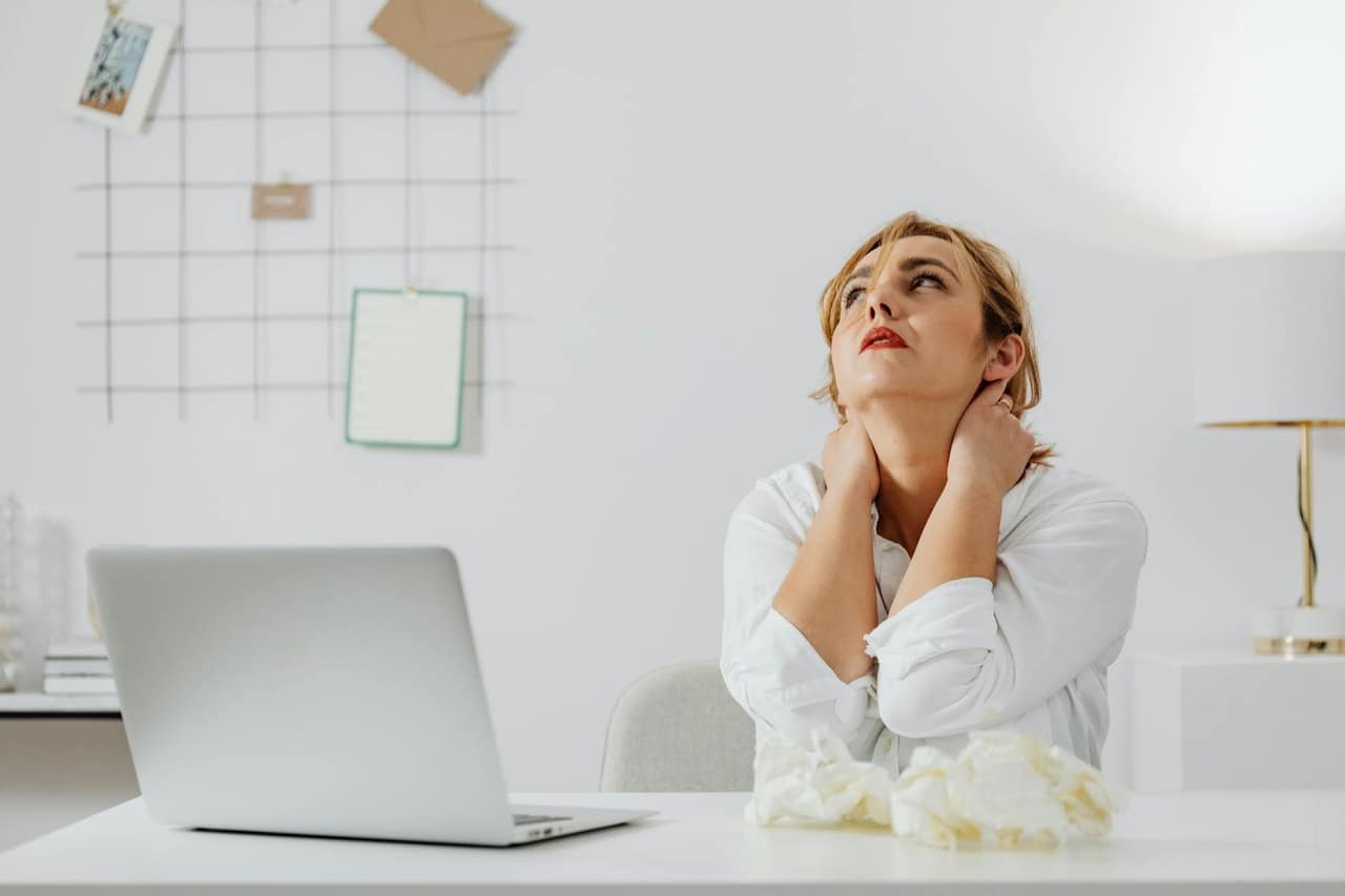 Woman experiencing cognitive overload symptoms while working at desk
