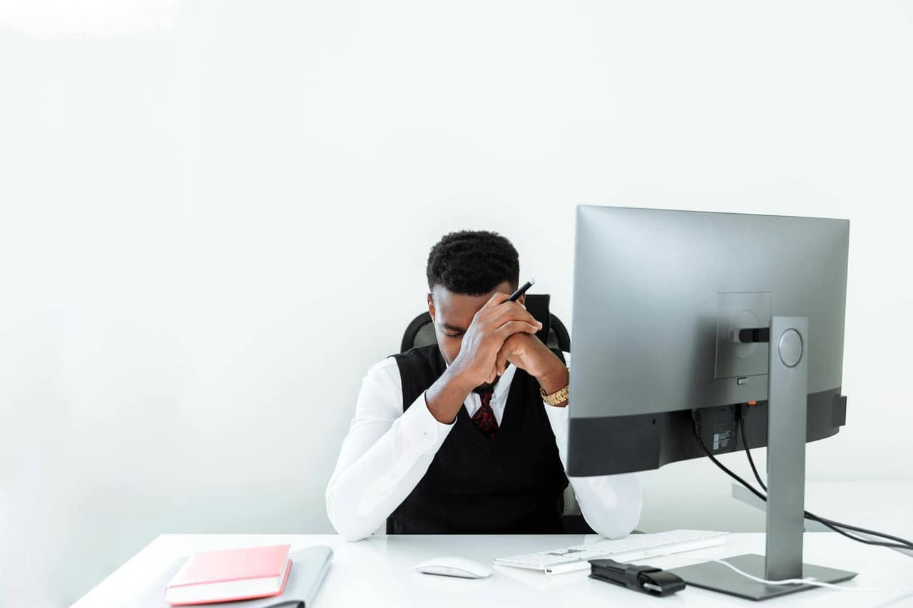 Businessman stressed at computer, representing procrastination struggle