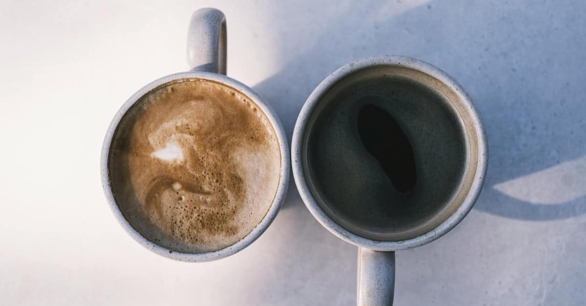 Two coffee cups on a sunlit table, seen from above, one full and one barely touched. The quiet morning scene of an unhappy marriage that has gone distant rather than loud.
