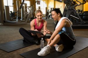 Adult female with personal trainer at gym