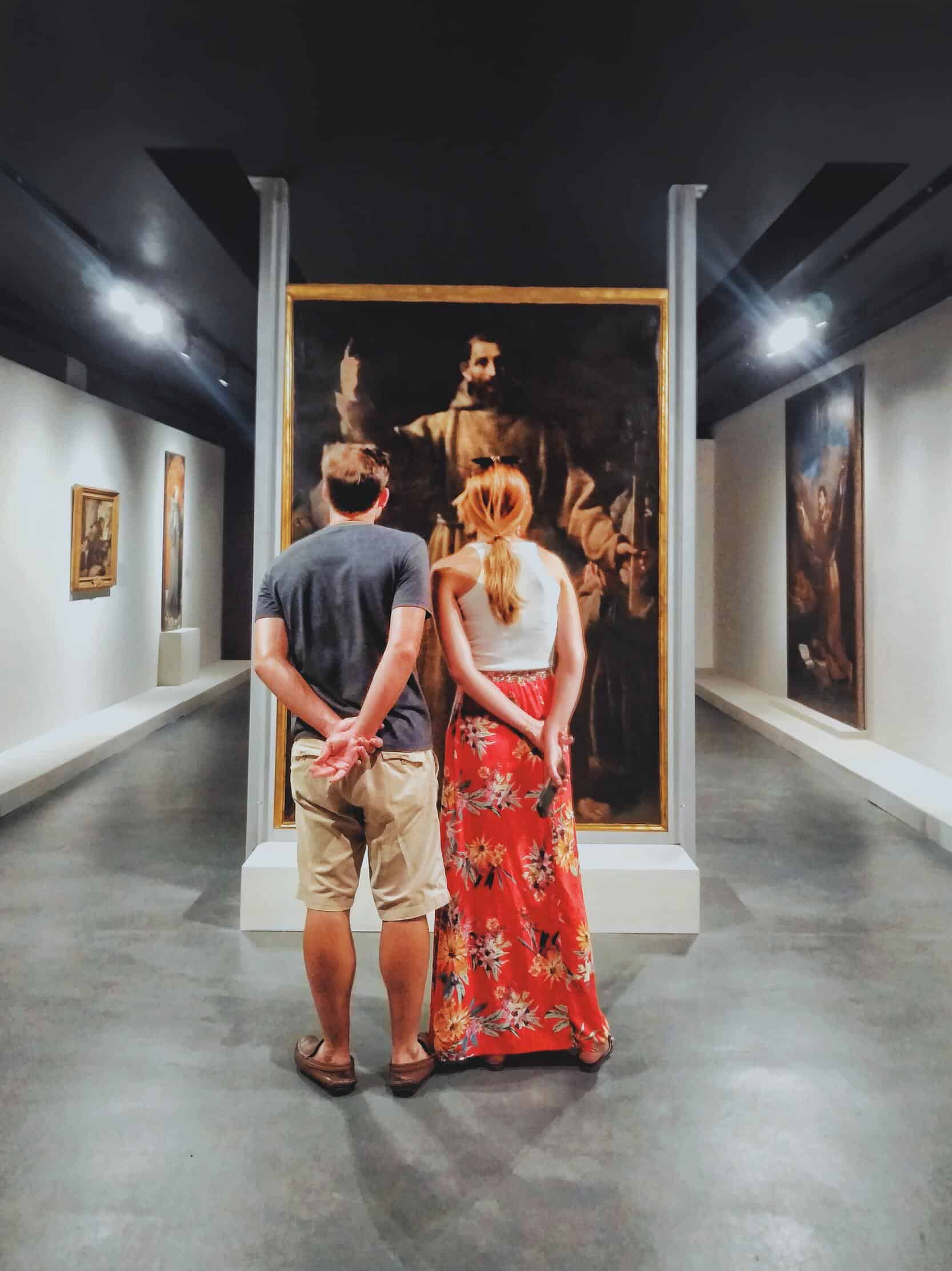 couple looking at a painting in a museum
