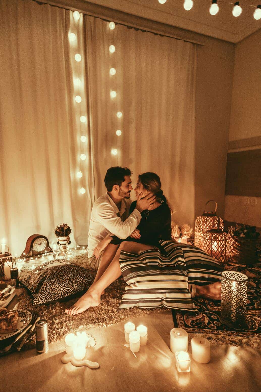 sweet couple with candles and pillows on the floor
