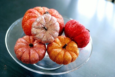 glitter-covered pumpkins in a variety of colors, set on a cake tray, and used as a centerpiece