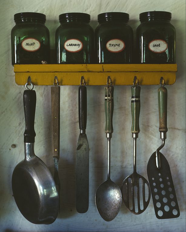 Jars on shelf top with hooks for cooking utensils