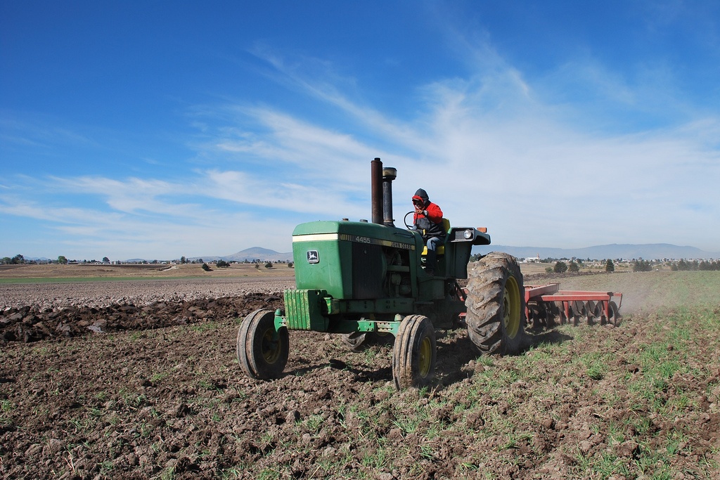 Фермер практикует использование трактора в полевых условиях