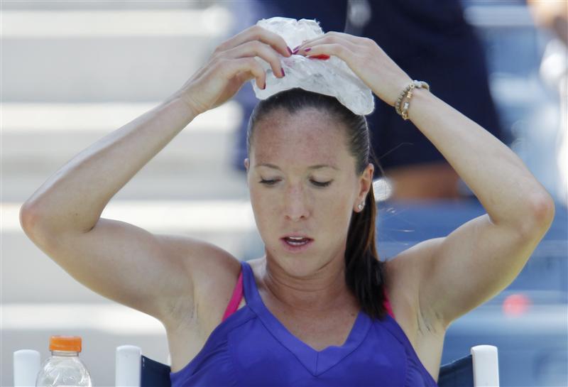 Jelena Jankovic of Serbia holds an ice pack on her head during her match against Simona Halep of Romania  during the U.S. Open tennis tournament in New York