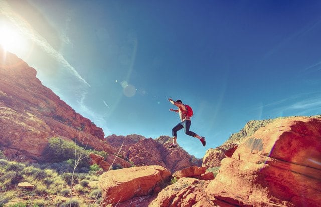 Athletic Man Jumping Between Rocks In Outdoor National Park