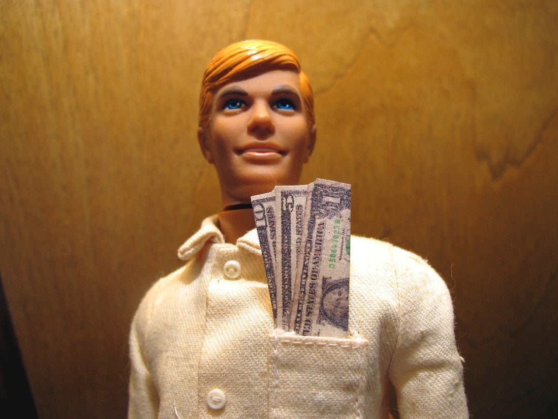 Ken doll with money in his pocket