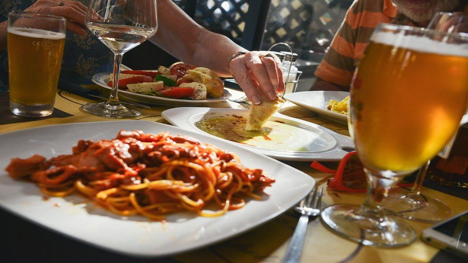 image of a plate of spaghetti beside a wine glass