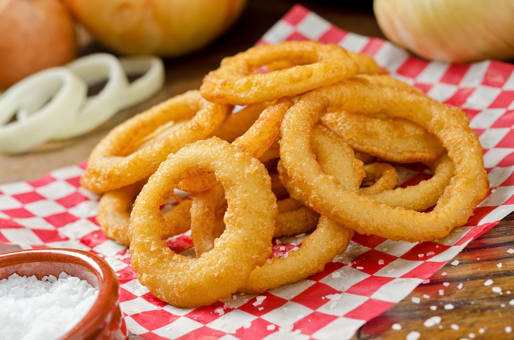 A serving of delicious breaded and deep fried golden brown onion rings.