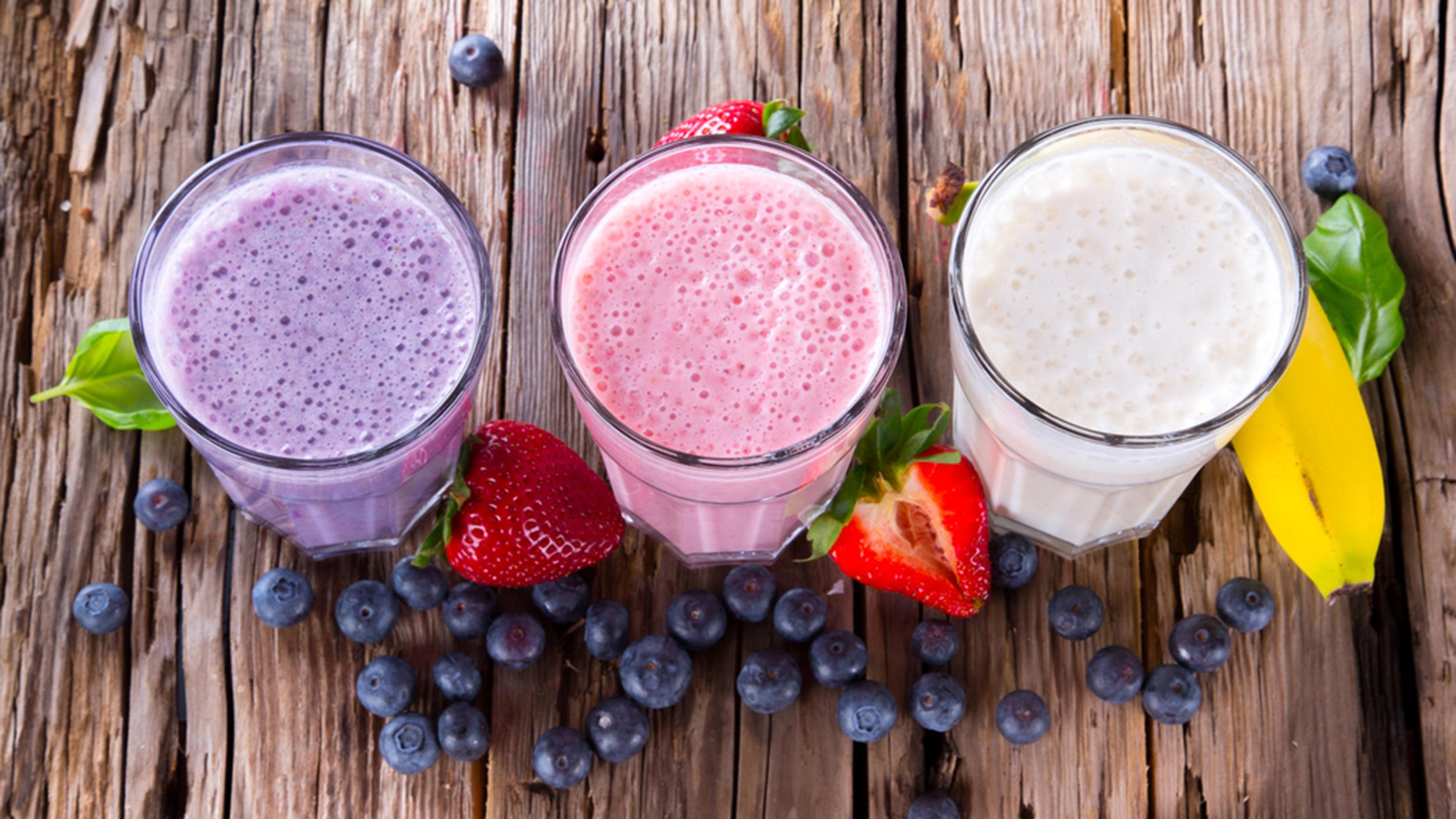 Fresh milk, strawberry, blueberry and banana drinks on wodeen table, assorted protein cocktails with fresh fruits. ; Shutterstock ID 182683421; PO: Brandon for Food