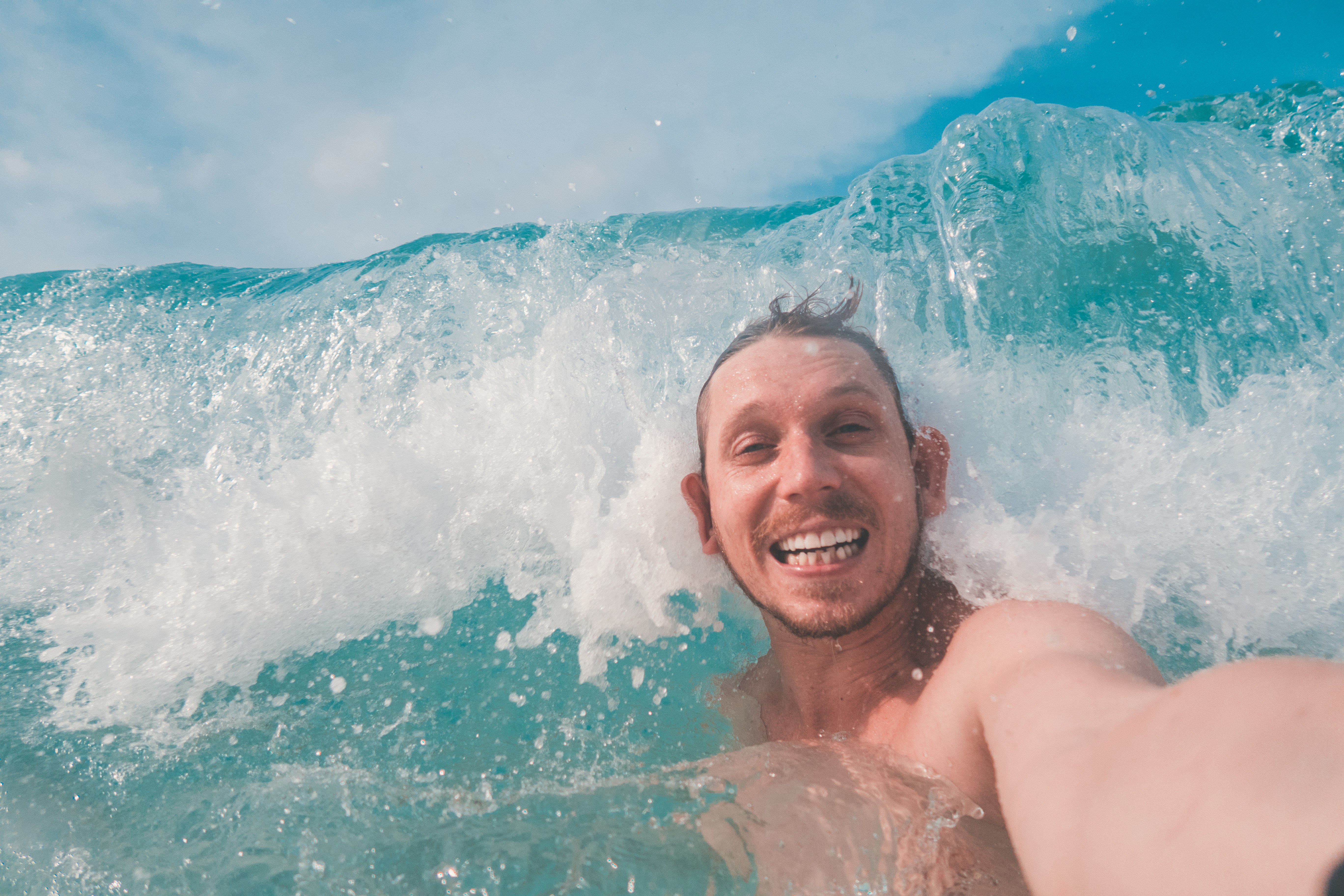surf-man-getting-hit-by-wave-whilst-taking-a-selfie
