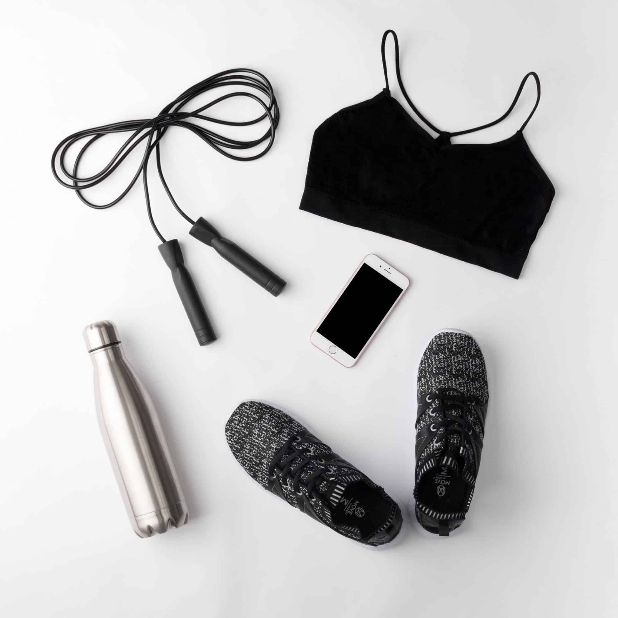 black and white exercise equipment and clothes for women laid out on the floor