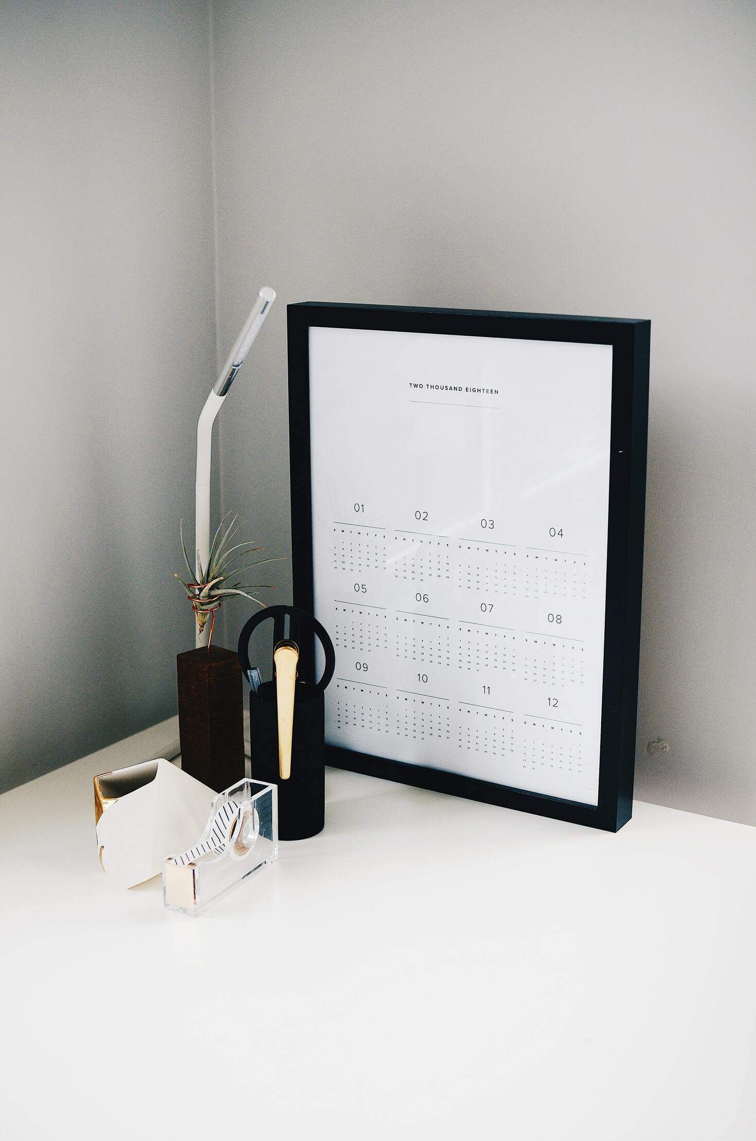 clean white desk with calendar and lamp