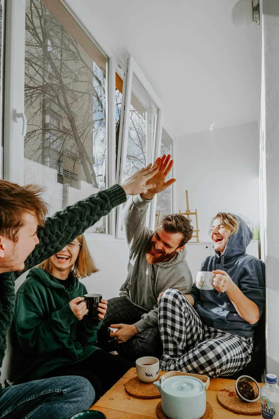 group of friends laughing and having fun together over tea