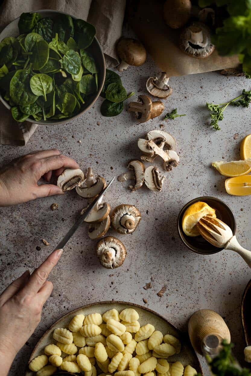 man cutting mushrooms at the table with other ingredients