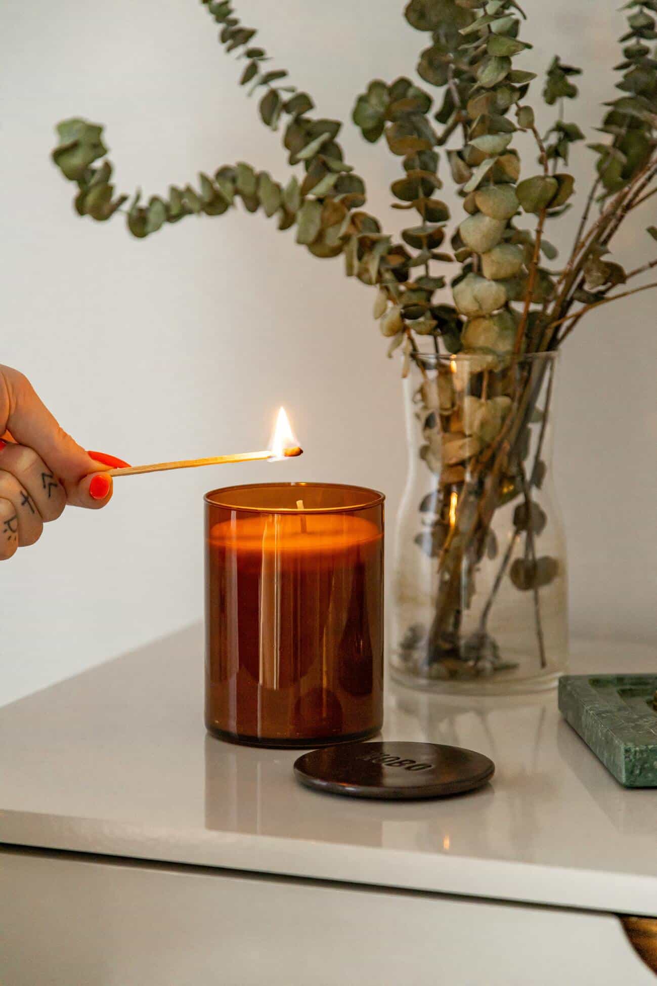 person lighting a candle on the table