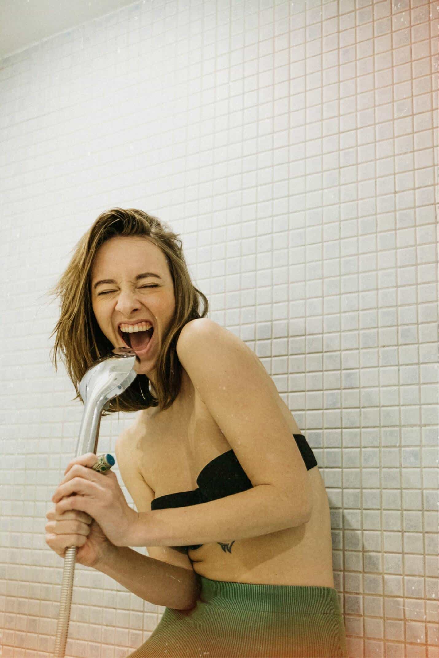 woman singing to hand shower